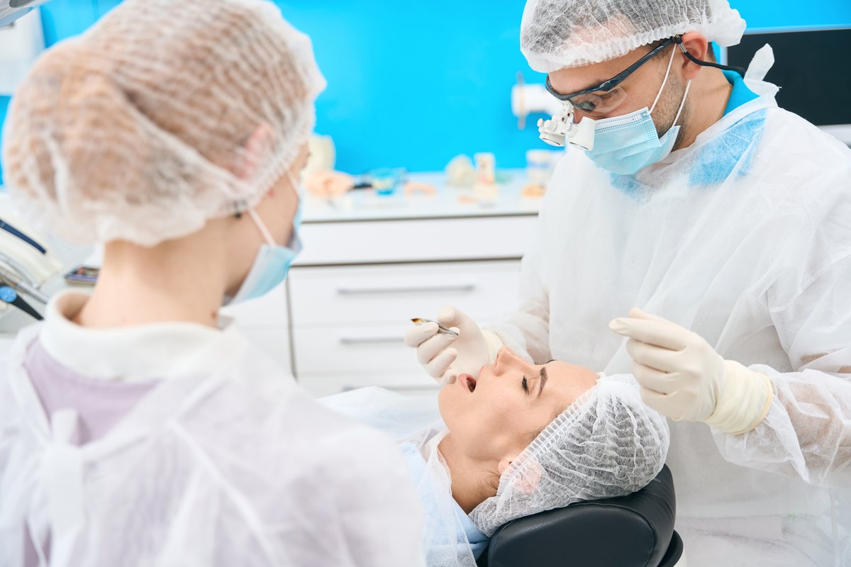 Odontologos tratando la zona perioral de una paciente durante una practica de armonización orofacial